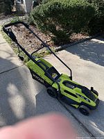 Full side view of Ryobi corded electric mower on driveway