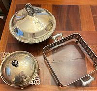 Top view of two round silverplate covered servers and square silver frame