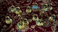 Both brass candelabra side by side on rug, showing full shape and all candle cups