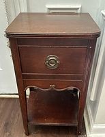 Front view showing drawer, pull, lower shelf, general design