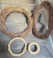 Four wreath bases of grapevine, wicker and straw on stairs