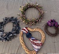 All four wreaths laid out on striped fabric background