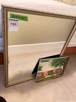 Framed wall mirror and ceramic plaque front view, size labels visible