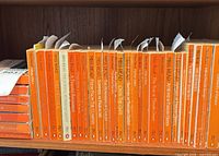 Shelf row of orange-spined Penguin Miss Read paperbacks