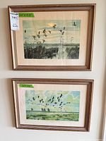 Both framed prints hung on wall