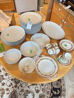 Assorted porcelain plates, bowls, platters, ladle and floral dinnerware on table