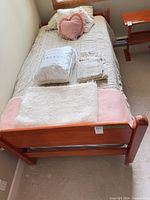 Full view of bed from foot showing frame, mattress, bedding