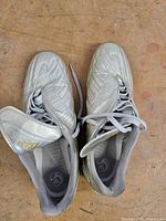 Top view showing silver uppers, grey laces, fold-over tongues with gold Adidas logo