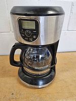 Front view of programmable coffee maker showing control panel, carafe and base