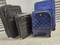 Four suitcases standing upright showing fronts