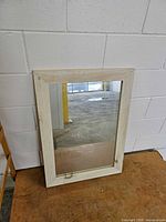 Front view showing light wood frame and mirror surface