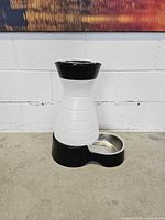 Front view of black and white automatic pet water dispenser with stainless steel bowl