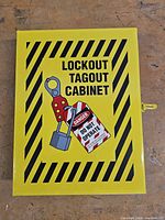Front view of yellow Lockout Tagout cabinet with graphics