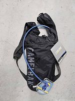 Front view of black CamelBak Hydrobak pack with blue hose and tags