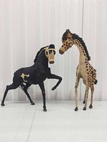 Horse and giraffe figures side by side front view