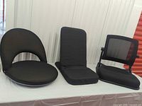 All three black adjustable floor chairs displayed side by side
