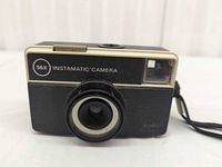 Front view showing Kodak Instamatic 56X lens, branding and wrist strap