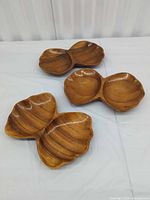 Three double-section wooden serving bowls displayed