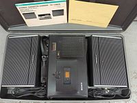 Recorder, speakers, power cord inside carrying case