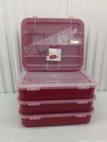 Front view of stack showing three boxes closed and one lid open displaying divider slots