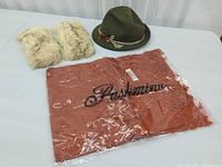 All three items together: fedora, shawl (in plastic), fur muffs