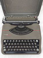 Front view of Hermes Rocket typewriter with lid attached at rear