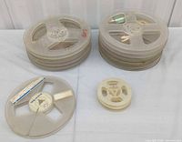 Two stacks of translucent plastic film reels plus separate larger and smaller reels