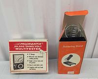 Boxed Micronta multitester beside boxed soldering stand