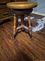 Full view of stool showing seat, legs, and casters