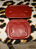 Top view of both red plastic lids showing size difference