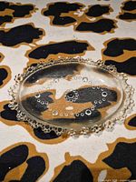 Top view showing oval smoked glass plate with beaded rim and interior design