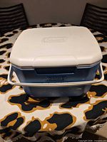 Front top view of the blue and white Coleman personal cooler showing lid and handle