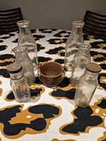 Group shot of six bottles and metal cauldron on table