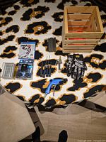 Overview of all items on table including crate, game, tools, gloves, charger, staples