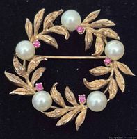 Front view showing pearls, pink stones, and gold leaf wreath design