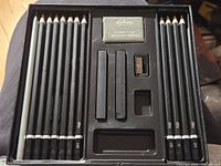 Open Studio Pro box showing pencils, sticks, eraser, sharpener and tray
