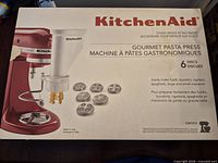 Front of box showing KitchenAid Gourmet Pasta Press attachment and six discs