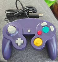 Front view of indigo Nintendo GameCube controller showing buttons, joysticks, D-pad and attached cable