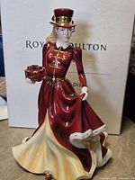 Figurine standing in front of box showing full attire and pose