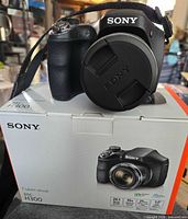 Camera on top of original box front view with lens cap