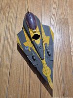 Top view of yellow and grey Jedi Starfighter toy showing cockpit and Republic insignia