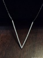 Front view showing stone-set V pendant and chain