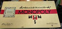 Top of beige 1951 Monopoly box with graphics and branding