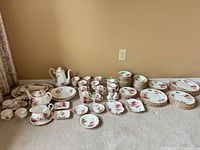Full set laid out on carpet showing quantity and variety of dishes