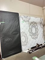 Mattress adjacent to box spring showing fabric pattern and underside color contrast