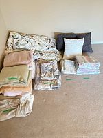 Entire lot laid out showing folded sheet sets, duvet, bed skirt and decorative pillows