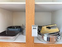Cabinet shelf showing all items including pans and hand mixer
