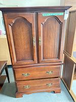 Full front view of solid cherry armoire showing two doors and two drawers