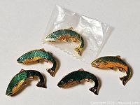 All five enamel fish pins, one in plastic
