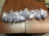 Seven large sealed plastic bags filled with clear plastic name tag holders for Beanie Babies.